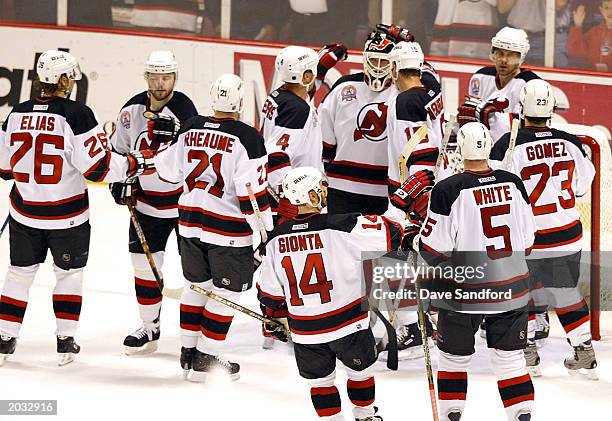 The New Jersey Devils congratulate Martin Brodeur after a victory over the Mighty Ducks of Anaheim in game one of the 2003 Stanley Cup Finals May 27,...