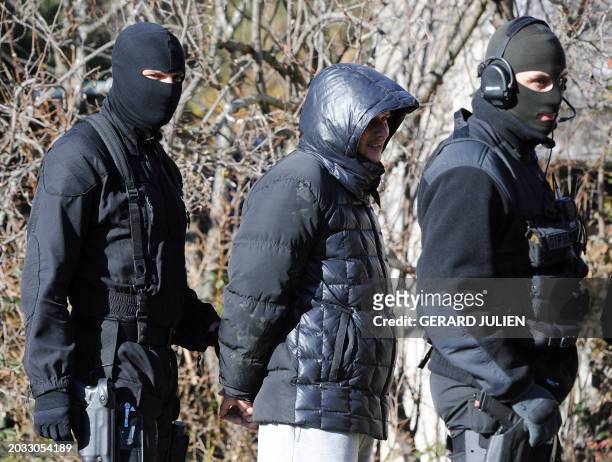 Des membres du GIPN escortent une personne après son arrestation, le 14 décembre 2010 autour d'une ferme à Célony près d'Aix-en-Provence, après la...