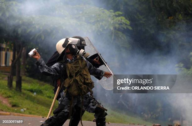 Riot police throw tear gas canisters at teachers standing a demonstration in Tegucigalpa, August 27, 2010. AFP PHOTO/Orlando SIERRA