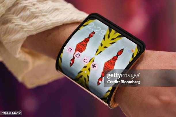 An attendee wears an adaptive smartphone display concept around their wrist at the Motorola Solutions Inc. Booth on the opening day of the Mobile...