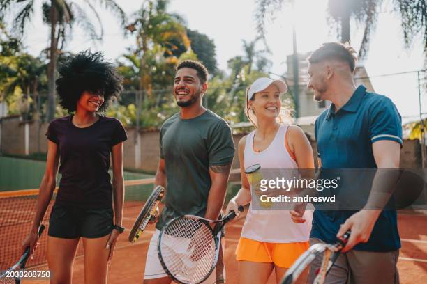 group of friends playing tennis on the court - racquet sport stock-fotos und bilder