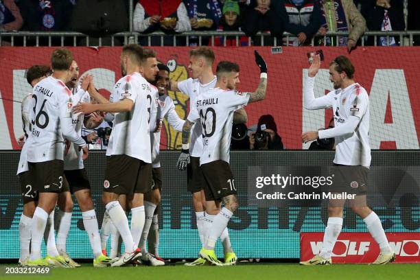 Oladapo Afolayan of FC St. Pauli celebrates scoring his team's third goal with teammates during the Second Bundesliga match between Holstein Kiel and...