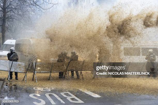 Tractor attacks the police barricade, blowing straw over the officers, during a Protest action of farmers' organizations 'Federation Unie de...