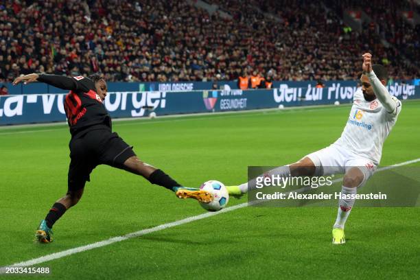 Jeremie Frimpong of Bayer Leverkusen challenges for the ball with Phillipp Mwene of 1.FSV Mainz 05 during the Bundesliga match between Bayer 04...