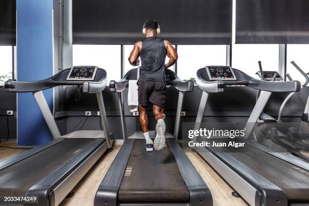 african american male running on the treadmill at the gym. - ejercicio-cardiovascular fotografías e imágenes de stock