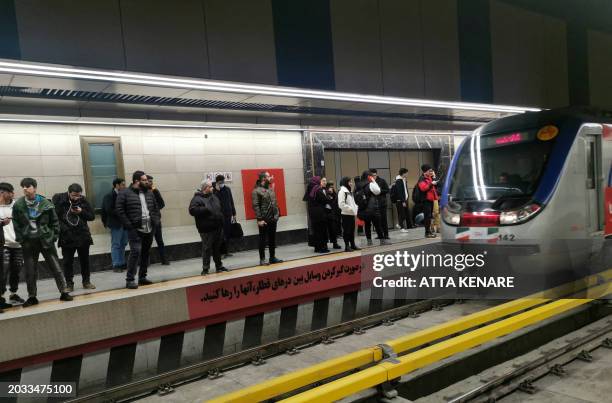 Commuters wait to board a metro train at a station in Tehran on February 26 ahead of next month's elections. Voters are due to cast their ballots on...