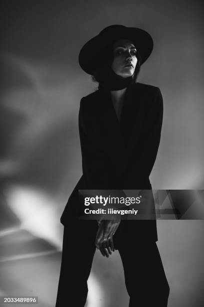 brunette woman in black suit and hat in studio. retro style - alta costura imagens e fotografias de stock