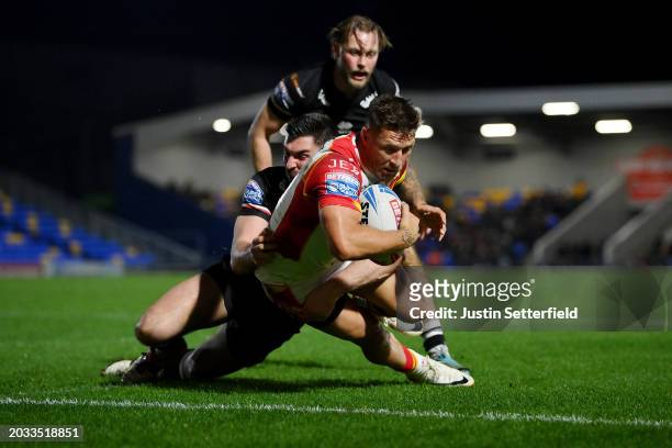 Tariq Sims of Catalans Dragons goes over to score his side's second try whilst under pressure from Will Lovell of London Broncos during the Betfred...