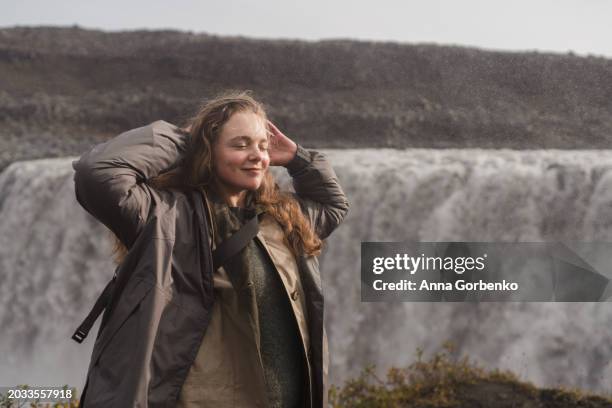 traveling and exploring iceland landscapes and travel destinations. female tourist watching spectacular scenery outdoors. dettifoss waterfall. - dettifoss waterfall stock pictures, royalty-free photos & images