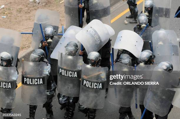 Riot policemen confront univeristy students during clashes on March 29 in Tegucigalpa. Students joined Honduran teachers on strike against the bid to...