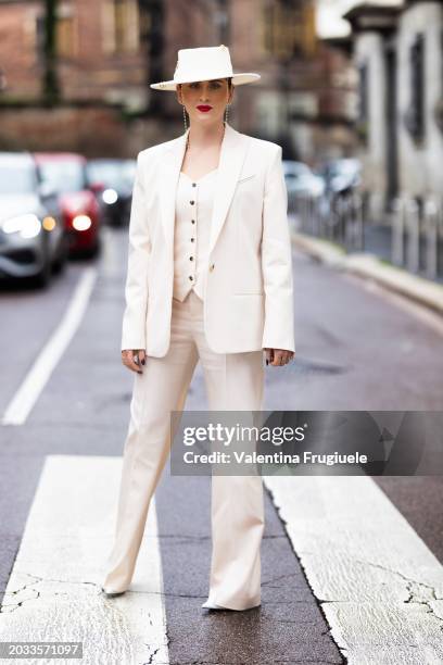 Valentina Ferragni is seen wearing a white cream hat with gold details, white shoes, a pearl glasses chain and a white cream suit made of a blazer,...