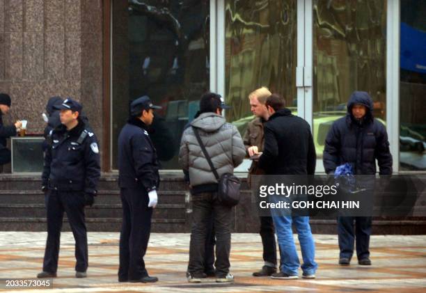 Chinese police surround a group of foreign journalists as security is ramped up, with at least 300 hundred uniformed police guarding the entrance to...