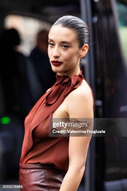 Maria Pedraza is seen wearing a terracotta red halter neck top with a bow detail on the side and a brown leather midi skirt outside Philosophy show...