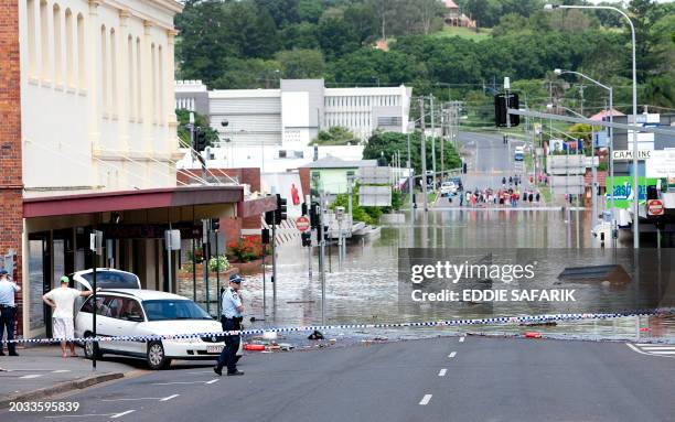 Police patrol a flooded Limestone Street in the Ipswich city centre, some 40 kms southwest of the Queensland city of Brisbane on January 12, 2011....