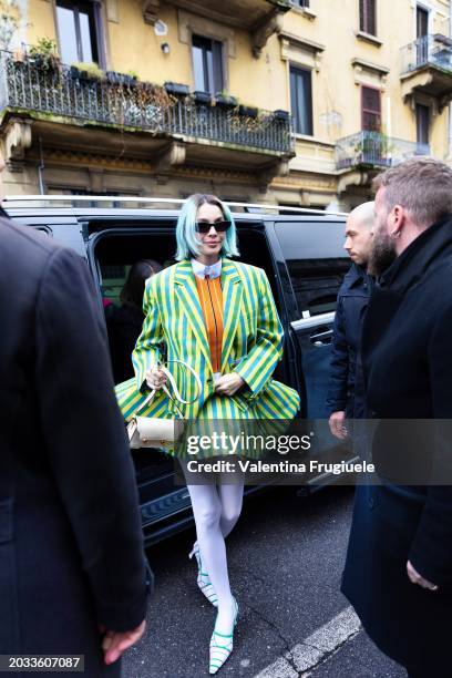 Rosa Chemical is seen wearing blue hair, black sunglasses, white tights, white and green pumps, a white leather bag, a white shirt, a light blue and...