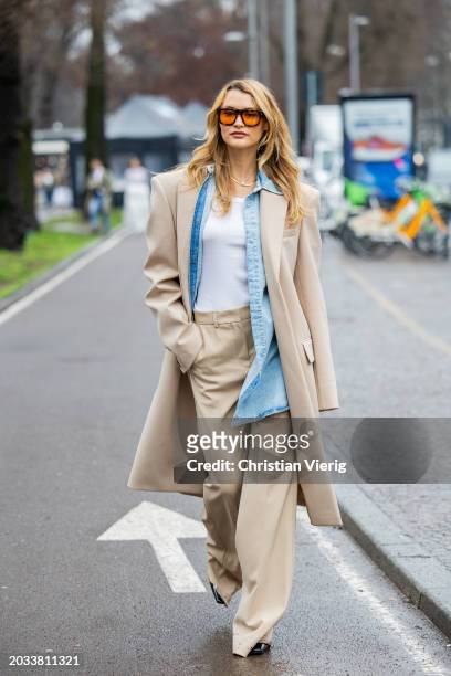 Chloe Lecareux wears beige coat, pants, denim button shirt, white shirt outside Sportmax during the Milan Fashion Week - Womenswear Fall/Winter...