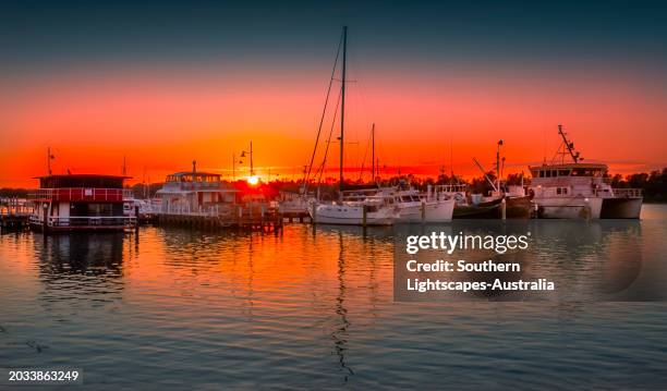 a summer dawn light castes a glow over the boats and harbour area at lakes entrance, east gippsland - gippsland lakes stock pictures, royalty-free photos & images