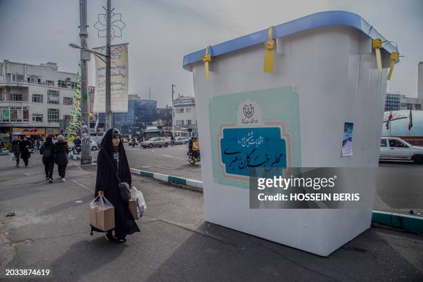 An Iranian woman passed by an exhibit showcasing a ballot box In Tehran, on February 24, 2024. Signaling the commencement of the election campaign....