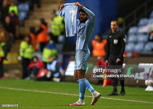 Coventry City's English striker Ellis Simms holds the shirt of his teammate Coventry City's Japanese midfielder Tatsuhiro Sakamoto as he celebrates...