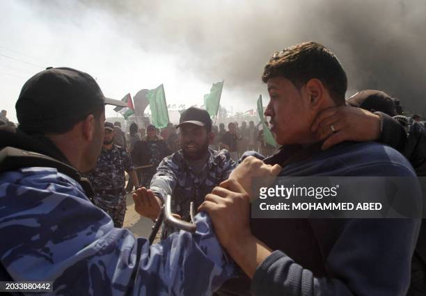 Members of Hamas security forces prevent Palestinian protesters as they try to reach the border between Israel and the northern Gaza Strip, during...