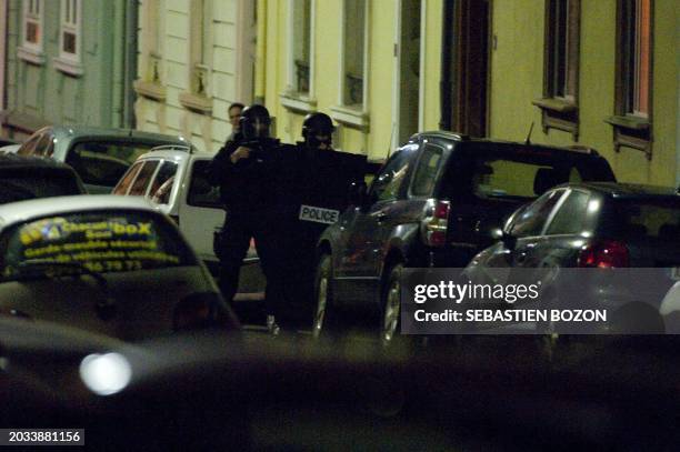 Members of the French GIPN unit stand in a street as a 41 year old man, drunk and armed sequesters his 12 year old girl in his apartment in Mulhouse...