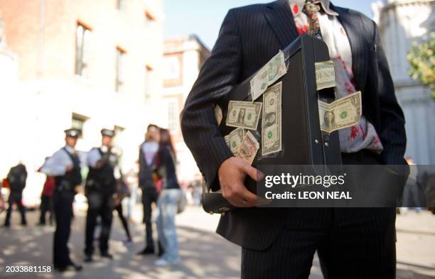 Man dressed as an "evil banker" stands outside St Paul's Cathedral in central London as protestors gather on October 15, 2011. A large group of...