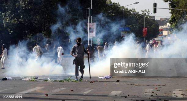 Activists of Pakistan's Jamaat-e-Sunnah and supporters of convicted killer Malik Mumtaz Hussain Qadri, disperse after police fire teargas during a...