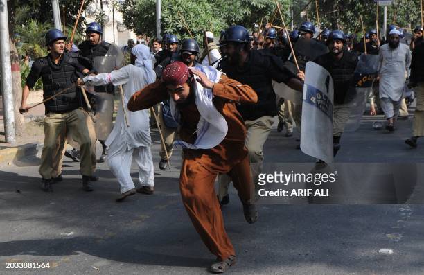 Pakistani riot police baton charge activists of Jamaat-e-Sunnah and supporters of convicted killer Malik Mumtaz Hussain Qadri during a protest in...