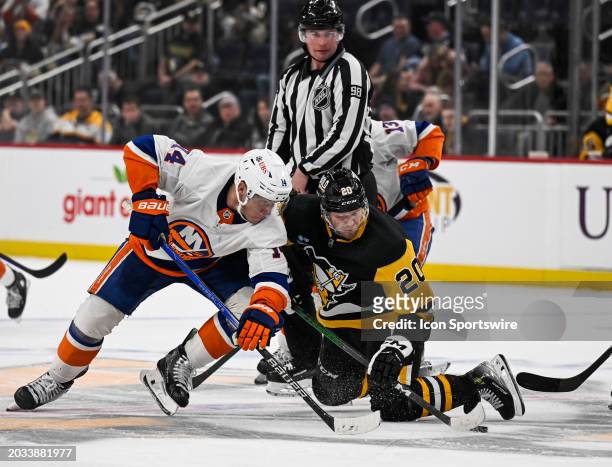 New York Islanders center Bo Horvat and Pittsburgh Penguins center Lars Eller go for the puck after a face-off during the overtime period in the NHL...