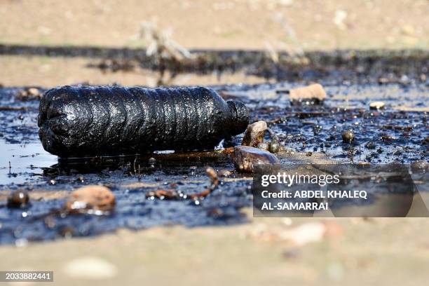 Picture shows a plastic bottle covered in oil after a spill into an agricultural land in the region of Hamrin, north of Tikrit, in Iraq's province of...