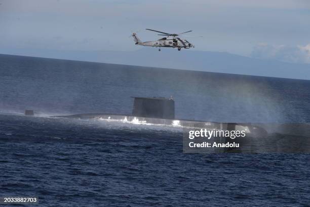 The Seahawk type helicopter stationed on the TCG Gediz frigate is training to deliver aid supplies to the Turkish Preveza-class submarine TCG...