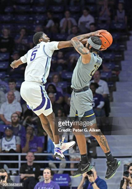 Cam Carter of the Kansas State Wildcats blocks the jump shot of RaeQuan Battle of the West Virginia Mountaineers in the second half at Bramlage...