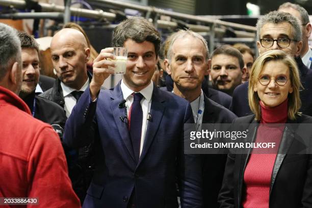 French Prime Minister Gabriel Attal holds a glass of milk near France's Deputy Minister for Agriculture and Food Sovereignty Agnes Pannier-Runacher...