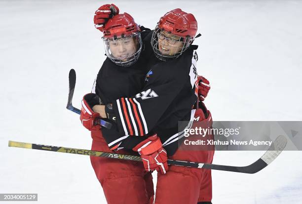 Qian Junhao L of Heilongjiang celebrates with teammate Liu Xuanyi after scoring a goal during the junior men's ice hockey semifinal match between...