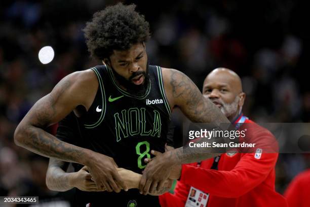 Naji Marshall of the New Orleans Pelicans is restrained during the fourth quarter of an NBA game at Smoothie King Center after an altercation with...