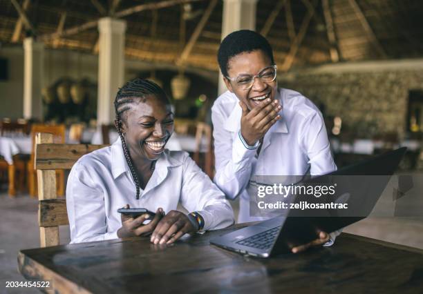 happy female students using laptop while e learning - áfrica oriental imagens e fotografias de stock