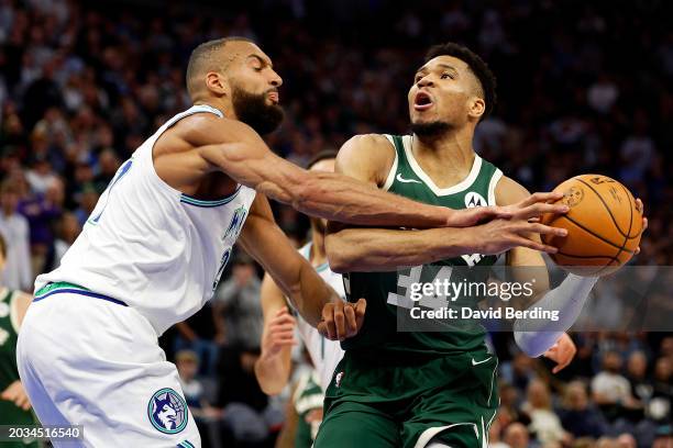 Giannis Antetokounmpo of the Milwaukee Bucks is fouled by Rudy Gobert of the Minnesota Timberwolves in the fourth quarter at Target Center on...