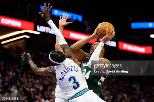 Giannis Antetokounmpo of the Milwaukee Bucks is fouled by Jaden McDaniels of the Minnesota Timberwolves in the fourth quarter at Target Center on...