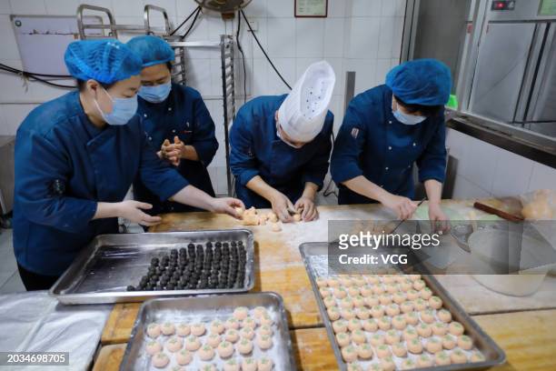 Employees make persimmon-shaped Yuanxiao, or Tangyuan, a dessert ball made of glutinous rice, to celebrate the Lantern Festival on February 23, 2024...