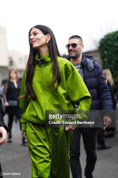 Gilda Ambrosio wears a green sportswear jacket with printed monogram / logo , sportswear flared pants, outside Gucci, during the Milan Fashion Week -...