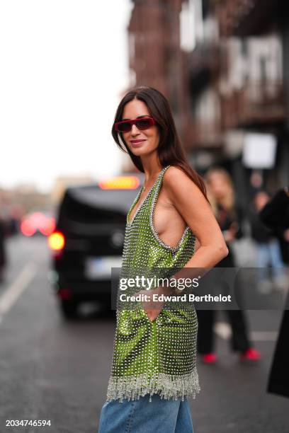 Gala Gonzalez wears sunglasses, a green sleeveless low-neck shiny sequined and fringed mini dress, outside Gucci, during the Milan Fashion Week -...