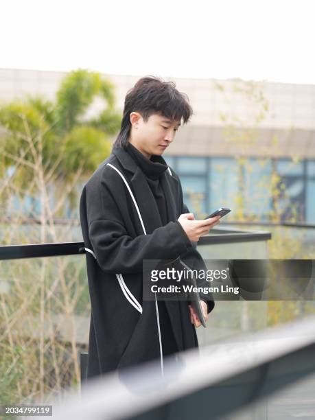 handsome man looking at mobile phone - xiamen stock pictures, royalty-free photos & images