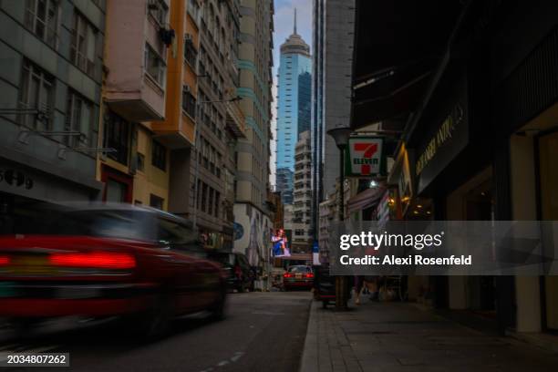 Taxis move through the narrow streets of Sheng Wan as skyscrapers around Central are seen in the distance on February 22, 2024 in Hong Kong, China....