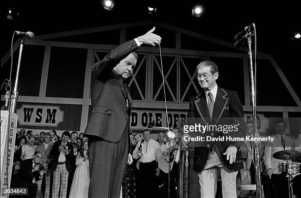 President Richard Nixon demonstrates his yo-yo skills to Roy Acuff March 16, 1974 at the dedication of the new Grand Ole Opry House in Nashville, TN.