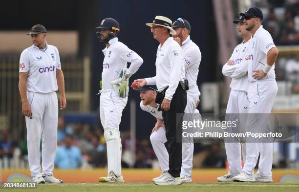 Ben Stokes of England goes low under umpire Rod Tucker to watch a screen replay of an attempted run out during day two of the 4th Test Match between...