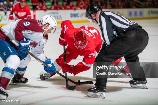 Linesman Dan Kelly drops the puck between Dylan Larkin of the Detroit Red Wings and Zach Parise of the Colorado Avalanche during the third period at...