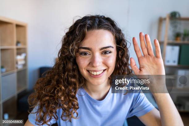 cheerful woman greeting during video call - film screening room stock pictures, royalty-free photos & images