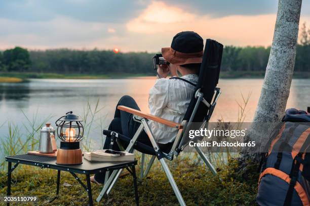 asian woman camping alone with tent on summer holiday. outdoor activity and lifestyle. - food silhouette stock pictures, royalty-free photos & images