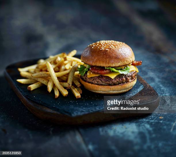 photo of a burger on dark slate background - burger on grill photos et images de collection