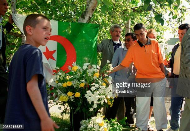 Des hommes et des jeunes gens déposent des fleurs, le 20 juin 2001 à Montigny-les-Cormeilles, lors d'une manifestation silencieuse à la mémoire de...